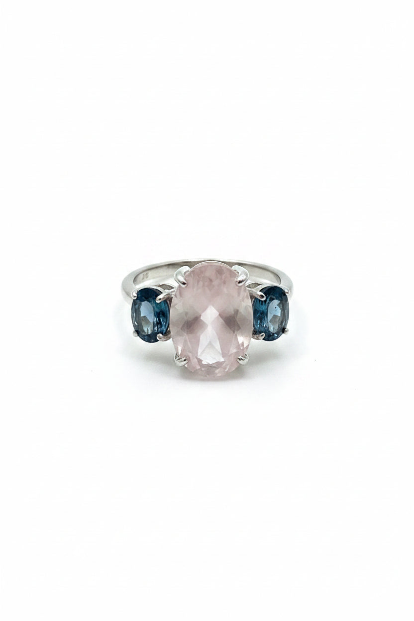 Ring with a pink stone and black gemstone on a marble surface