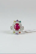 Red gemstone ring with AGA Gem Analysis Lab identification report on a dark surface
