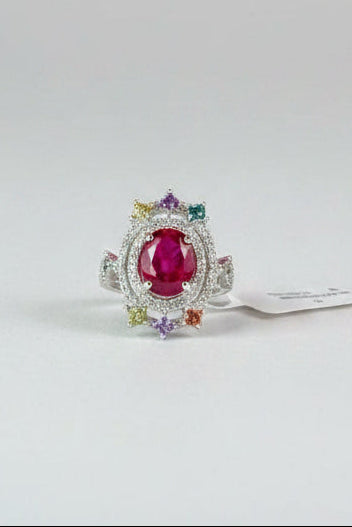 Red gemstone ring with AGA Gem Analysis Lab identification report on a dark surface